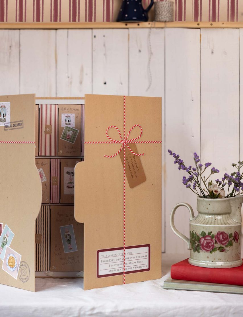 Geöffneter Kalender mit Blumenkrug und Kordel